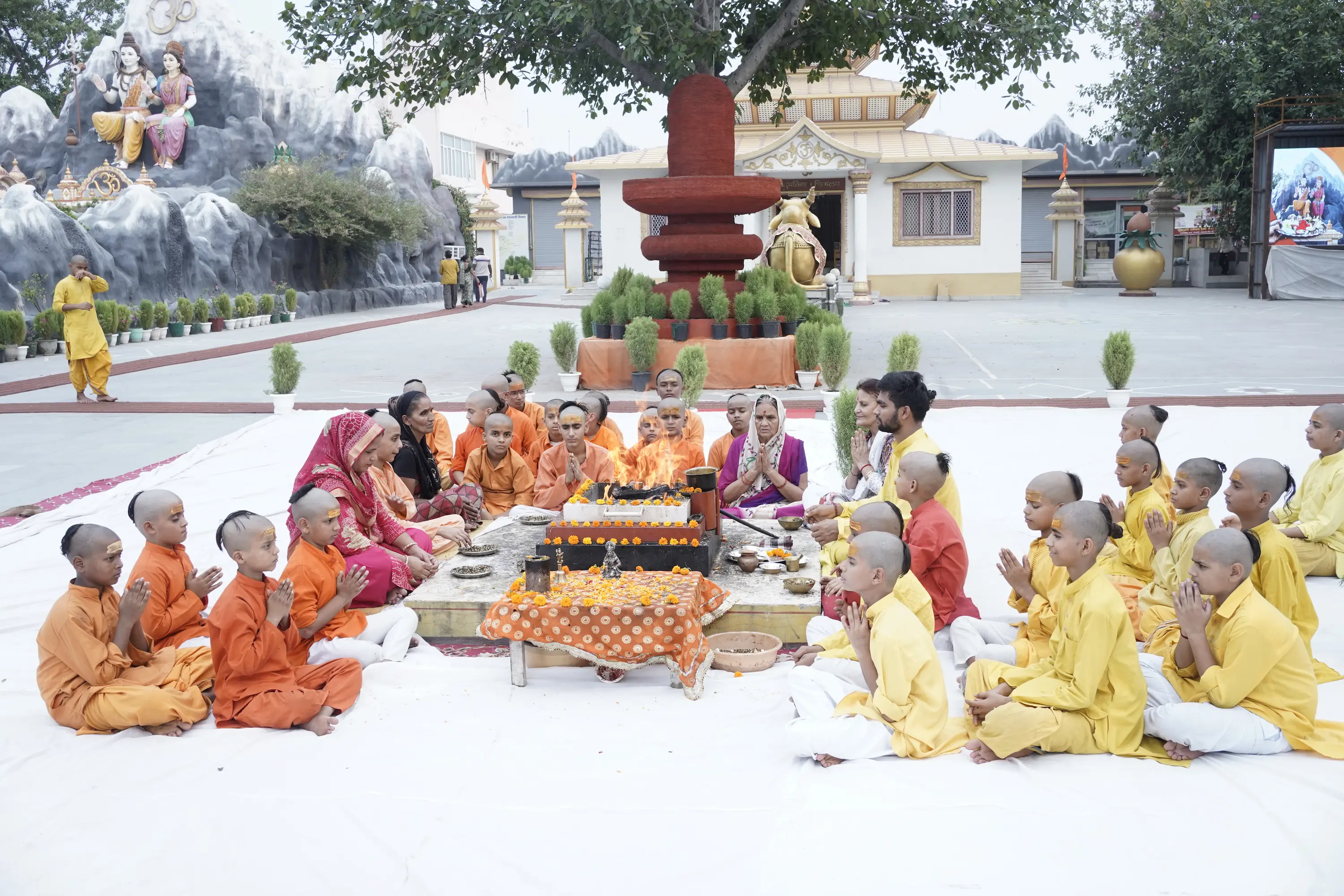 Priests and young devotees gathered around a sacred fire for pooja at Shiv Vardaan Teerth